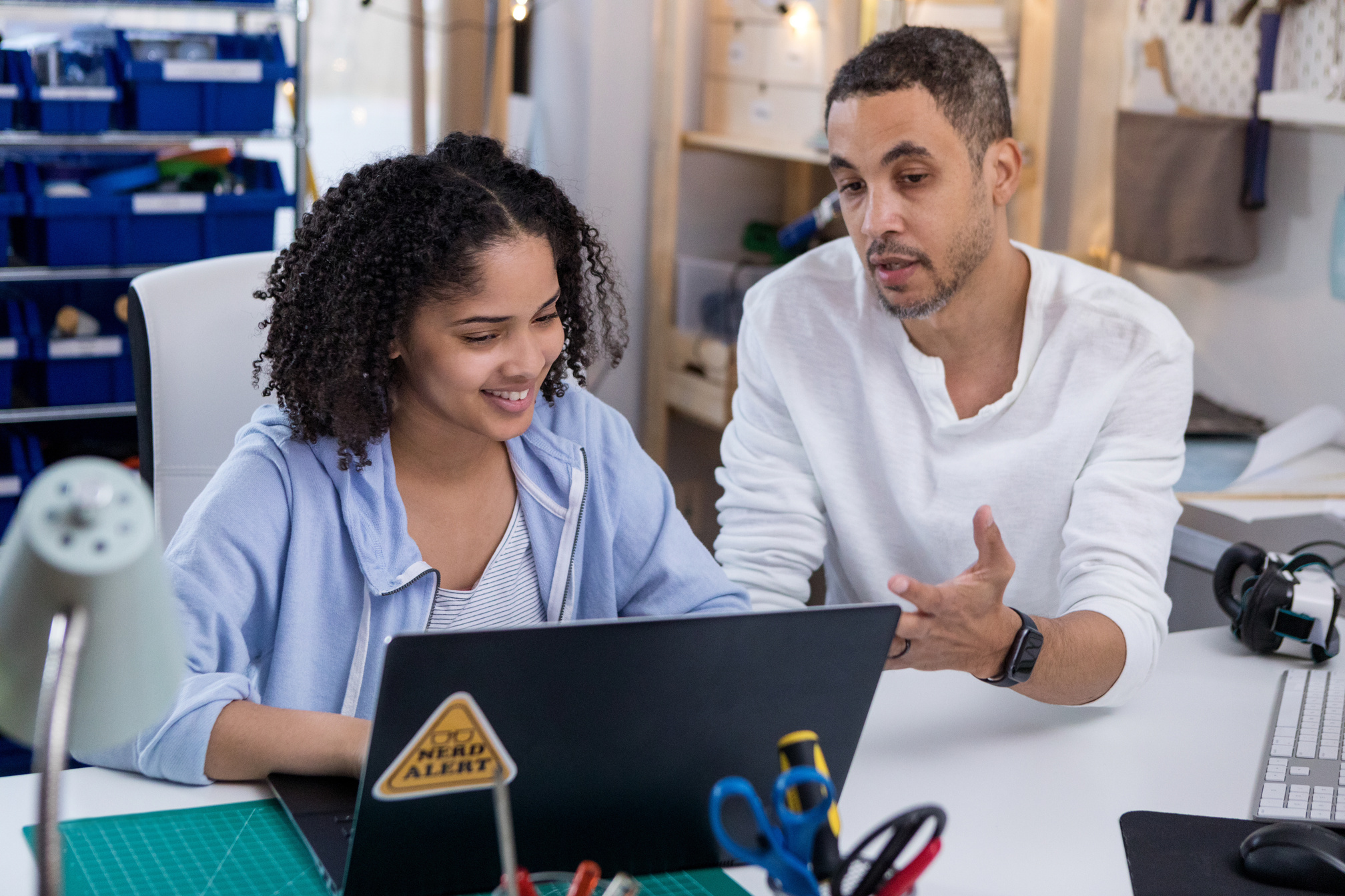 Mid adult dad teaches teen about computer program